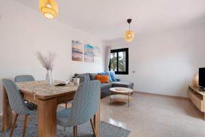 ein Wohnzimmer mit Tisch und Couch in der Unterkunft Margarita - Oasis Duna in Corralejo