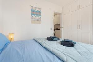 ein blaues Bett mit zwei Handtüchern darüber in der Unterkunft Margarita - Oasis Duna in Corralejo + 24 Fotos