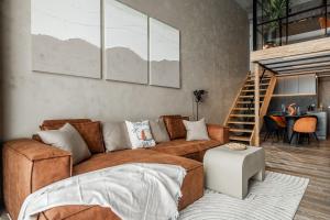 a living room with a brown couch and a table at Rusty Wave Loft in Central Klaipeda in Klaipėda