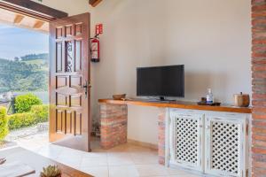 - un salon avec une télévision et une porte avec une fenêtre dans l'établissement Las Candelas - Puerto Calderón, à Oreña
