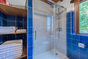 une salle de bain avec douche aux carreaux bleus dans l'établissement Las Candelas - Puerto Calderón, à Oreña 36 autres photos