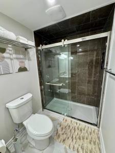 een badkamer met toilet en glazen douche bij 2 BR Private Basement Suite | Minutes from YYZ in Brampton +11 foto's