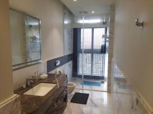 a bathroom with a large sink and a shower at Leela Lifestyle Apartment in Bangalore in Bengaluru