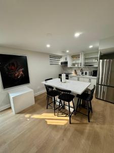een keuken met een tafel, stoelen en een koelkast bij 2 BR Private Basement Suite | Minutes from YYZ in Brampton