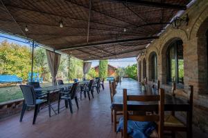 a patio with tables and chairs in a building at Il Castagneto Country Retreat in Pozzuolo