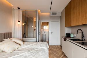 a bedroom with a bed and a kitchen with a shower at Bathtub and View 21st Floor The WAW Sawa in Skorka
