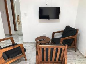 a room with two chairs and a table and a tv at Catamarca 4855 Fondo Izquierda in La Lucila del Mar
