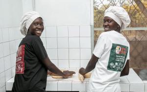 due bambini sono in piedi in una cucina e stanno preparando il pane di Nioko Bokk ad Abémé