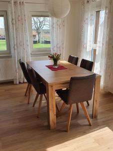 una mesa de comedor de madera con sillas y un jarrón de flores en Fuchskreuzhof, en Simmersfeld 10 fotos más