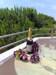 een fles wijn op een tafel met glazen bij Casa Mare in Durrës