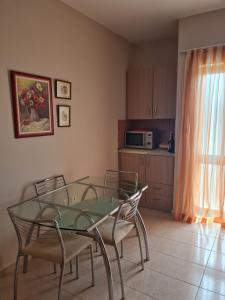 een eetkamer met een glazen tafel en stoelen bij Casa Mare in Durrës +1 foto