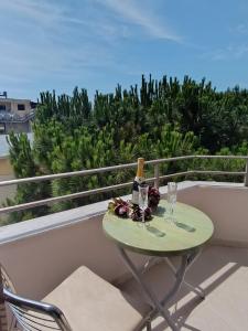 een tafel met een fles wijn en glazen op een balkon bij Casa Mare in Durrës