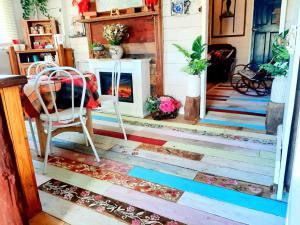 a living room with a fireplace and a chair at Rosewood Cottage -Entire 2 bedroom home with Netflix & WiFi in Tambo +34 photos