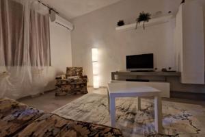a living room with a tv and a table and a couch at San Miniato 2-Bed Villa Sleeps 6 with Parking in San Romano