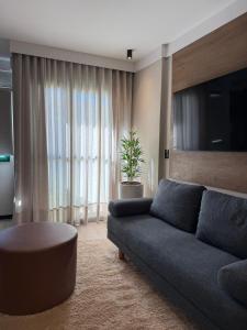a living room with a couch and a large window at Flat Blue Praia de Camburi in Vitória