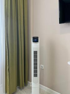 a room with a heater in front of a curtain at Sholpan City in Almaty +4 photos