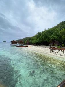a beach with a boat in the water at Keruwo Homestay in Waisai +66 photos