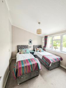 a bedroom with two beds and a window at Cosy Lakeside Lodge - Water Views - Min 3 Night Stay in Dunning