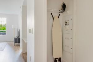 ein weißer Raum mit einem Surfbrett an der Wand in der Unterkunft Blueground Santa Clara washer nr Central Park SFO-1880 in Santa Clara