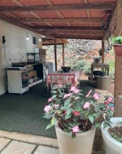 Una maceta con flores colocada bajo un patio cubierto. en Casa da Jeje, en Santa Teresa