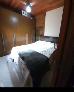 Un dormitorio con una cama con una manta negra. en Casa da Jeje, en Santa Teresa