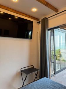 a bedroom with a bed and a sliding glass door at Agora Sundeck Tsikhisdziri in Ts'ikhisdziri