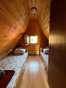 a room with two beds in a wooden cabin at Vikendica Ksenija in Jasikovice