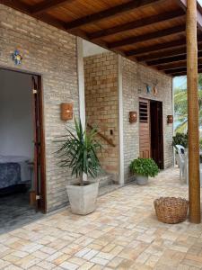 ein Haus mit einer Topfpflanze auf einer Terrasse in der Unterkunft Casa Farol - Praia de Itarema, CE in Itarema + 4 Fotos