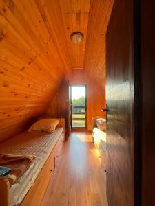 a small room with a bed and a window at Vikendica Ksenija in Jasikovice