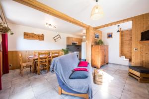 Una sala de estar con un sofá azul y una mesa. en Pré-vernay 7pers, en Saint-Jean-dʼArves