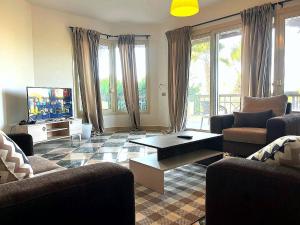 a living room with couches and a tv and a table at 3-BR Duplex - Near Beach & Hotel in Einbay l Wifi in Ain Sokhna