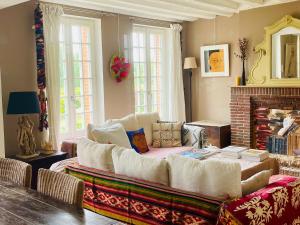 a living room with a couch and a fireplace at Juste le bruit des fleurs in Saint-Nicolas-de-Sommaire