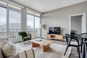 een woonkamer met een bank, stoelen en een tv bij Blueground Mountain View pool nr Shoreline Park SFO-1324 in San Francisco