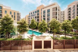 an apartment complex with a pool in front of buildings at شقة استوديو فاخرة في الزاهية الشارقة - cozy Studio in Sharjah