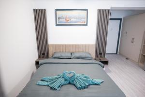 a bed with a blue bow on top of it at White Titanic Sea View in Mamaia Nord
