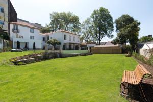 a yard with a bench in front of a house at bnapartments Carregal in Porto