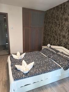 Una cama grande con dos flores blancas. en Villa Malazzo, en Balatongyörök