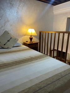 a bedroom with a bed with a lamp on a table at Riad Diafa in Oulad Akkou