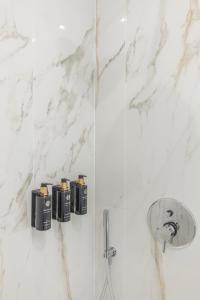 ein Bad mit weißen Marmorwänden und einer Dusche in der Unterkunft Vatican Pertusa Luxury Suites by Quinto Piano in Rom
