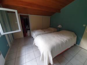 deux lits dans une chambre aux murs verts dans l'établissement CARCANS MAUBUISSON LOCATION SAISONNIERE VILLA 6 couchages, à Carcans