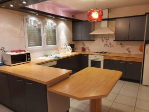 une cuisine avec des armoires noires et un comptoir en bois dans l'établissement CARCANS MAUBUISSON LOCATION SAISONNIERE VILLA 6 couchages, à Carcans