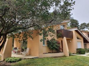 une maison avec une table et des chaises dans la cour dans l'établissement CARCANS MAUBUISSON LOCATION SAISONNIERE VILLA 6 couchages, à Carcans