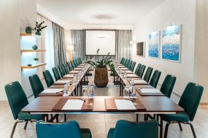 a large conference room with long tables and green chairs at The Chedi Luštica Bay in Tivat +37 photos