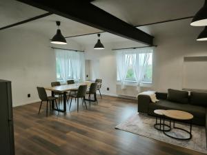 a living room with a couch and a table and chairs at Apartmány ve statku in Vchynice