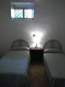 two beds in a room with a window at Casa Rural Masía Barbera in Ibi