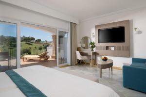 sypialnia z łóżkiem, biurkiem i telewizorem w obiekcie La Cala Resort w mieście La Cala de Mijas