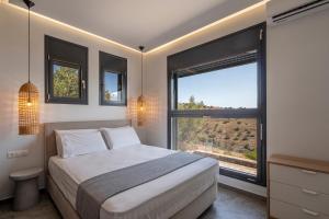 a bedroom with a bed and a large window at Villa Melisea in Sfendoúrion