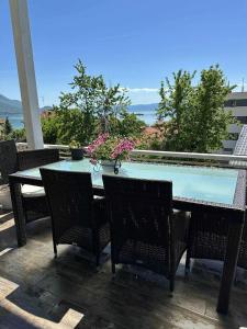 a table and chairs on a patio with a view of the ocean at Lake & Mountain retreat in Lagadin, OHRID in Lagadin