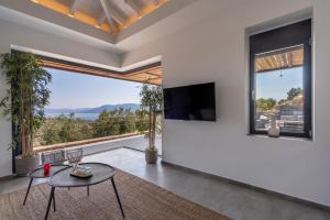 a living room with a table and a large window at Villa Melisea in Sfendoúrion +16 photos
