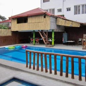 a building with a swimming pool with a house at Pansol Playhouse Private Resort in Calamba